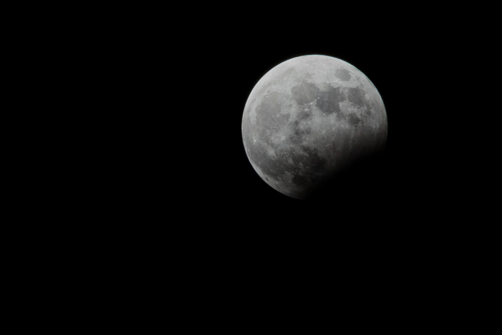 Big moon on the right with lots of black negative space around it.